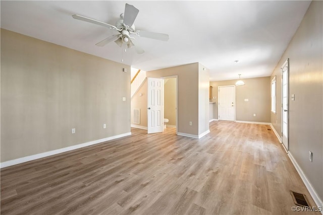 unfurnished room with visible vents, ceiling fan, light wood-style flooring, and baseboards