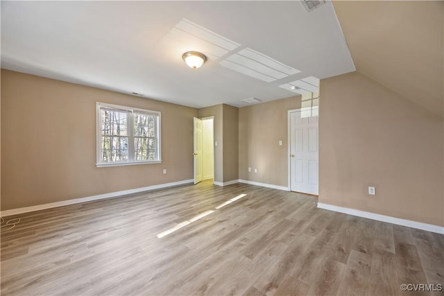 bonus room featuring light wood-type flooring, visible vents, baseboards, and lofted ceiling