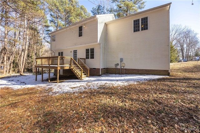 snow covered rear of property with crawl space, a deck, and stairs