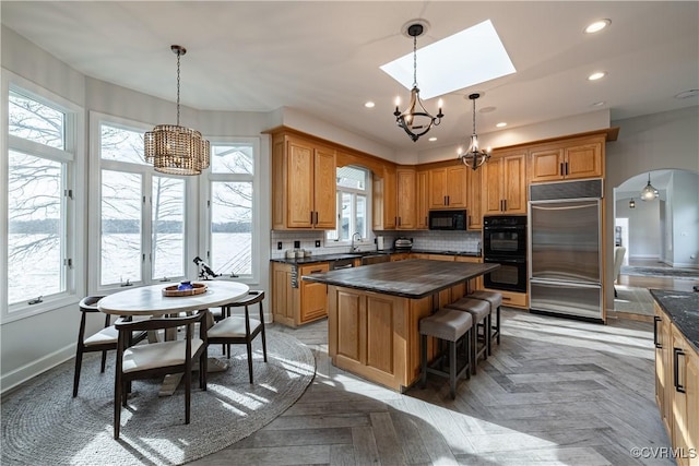 kitchen featuring a chandelier, black appliances, and dark countertops