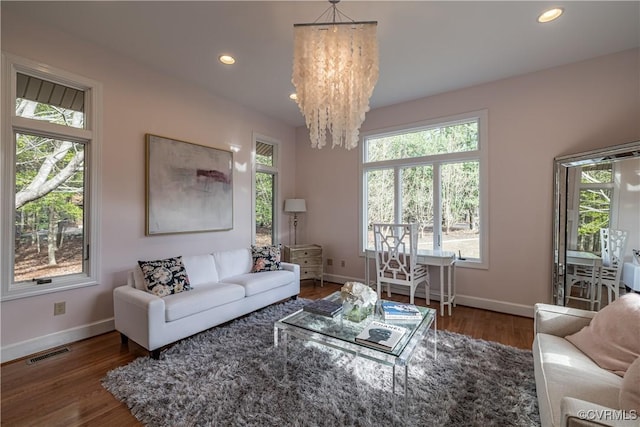 living room featuring visible vents, baseboards, and a healthy amount of sunlight