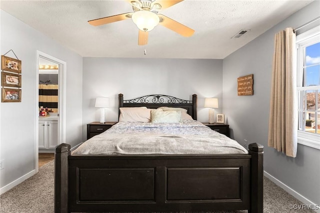 bedroom with carpet floors, visible vents, a textured ceiling, and baseboards