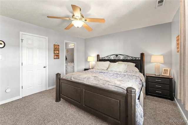 bedroom featuring baseboards, visible vents, light colored carpet, ensuite bath, and ceiling fan