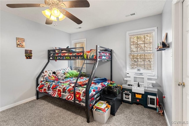 carpeted bedroom with ceiling fan, visible vents, and baseboards