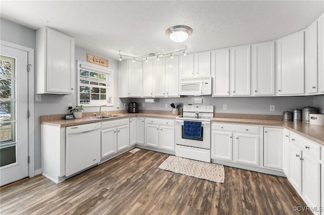 kitchen featuring white appliances, white cabinetry, light countertops, and a sink