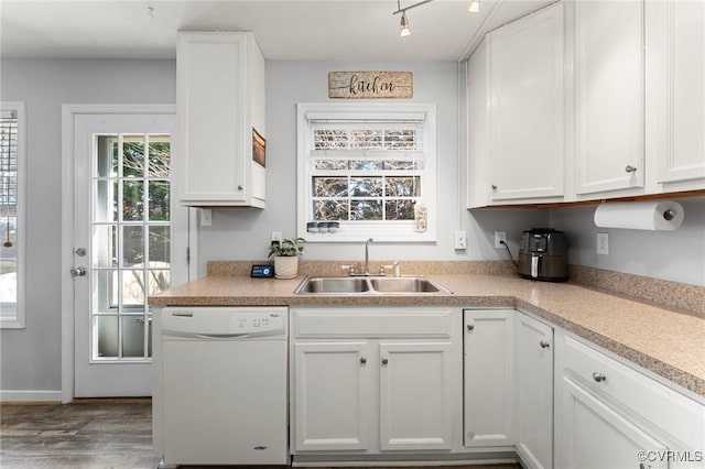 kitchen with white cabinets, a sink, light countertops, and dishwasher