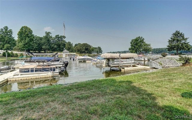 view of dock with a lawn and a water view