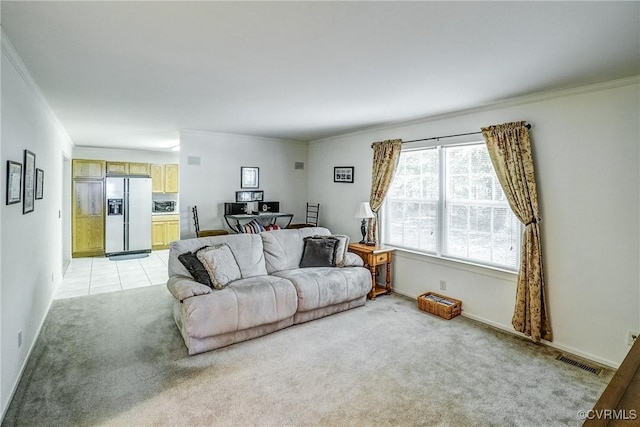 living room with ornamental molding, light colored carpet, visible vents, and baseboards