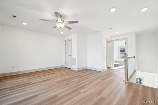 empty room featuring baseboards, light wood-type flooring, visible vents, and recessed lighting