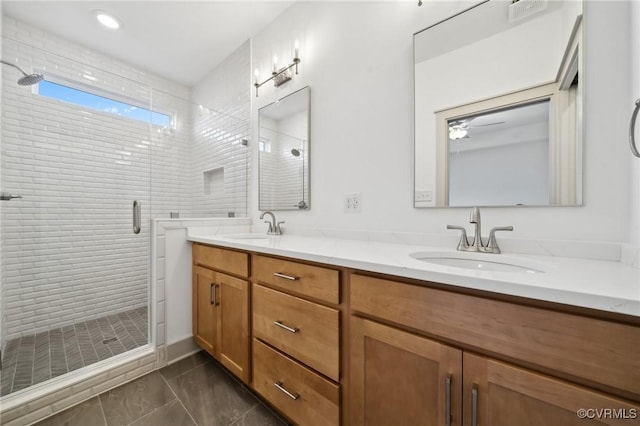 bathroom featuring double vanity, a sink, and a shower stall