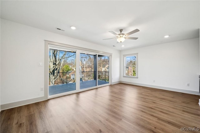 spare room with recessed lighting, wood finished floors, visible vents, and baseboards