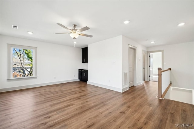 unfurnished living room with ceiling fan, baseboards, dark wood-style flooring, and recessed lighting