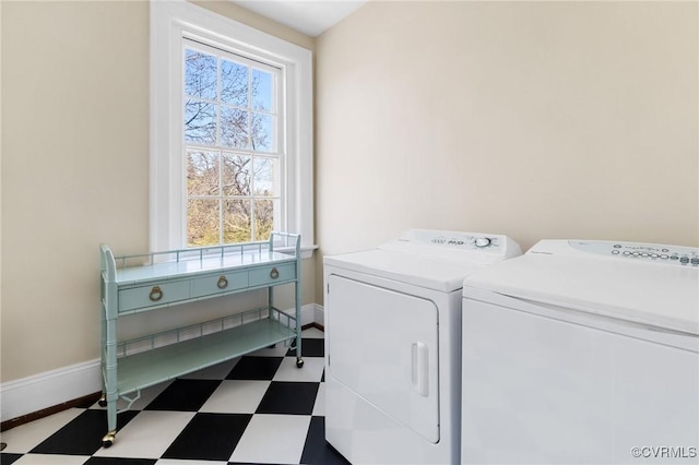 laundry room with laundry area, washing machine and dryer, baseboards, and tile patterned floors