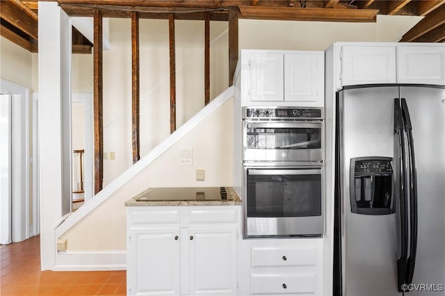 kitchen with light tile patterned floors, appliances with stainless steel finishes, white cabinets, and light countertops