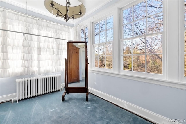 interior space featuring a chandelier, carpet, radiator, and baseboards