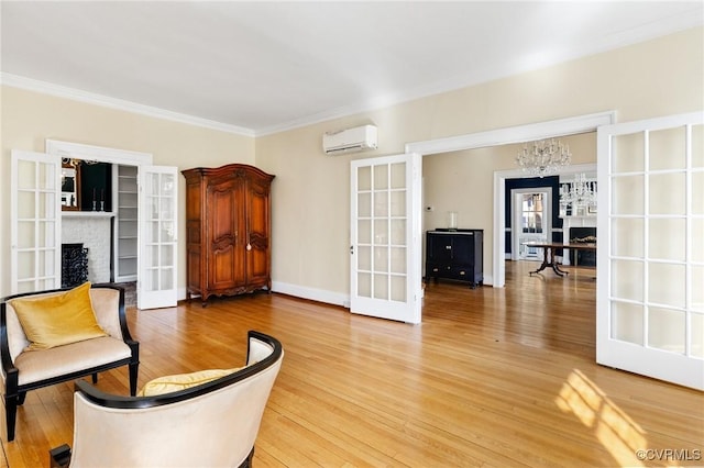 living area with light wood-style floors, french doors, a wall mounted air conditioner, and ornamental molding