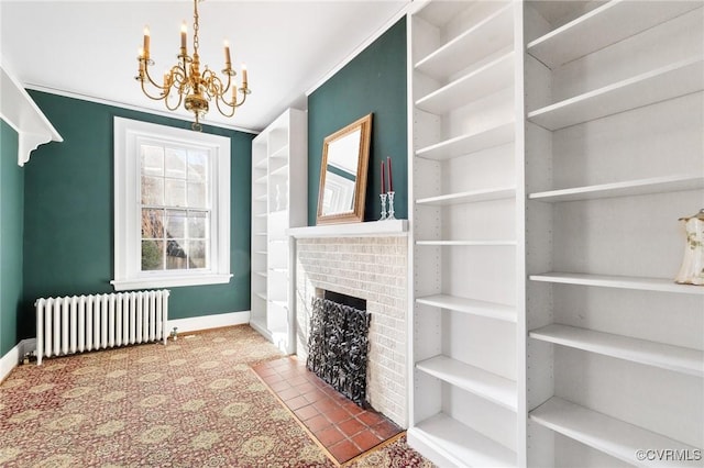 living room featuring crown molding, a fireplace, a notable chandelier, radiator heating unit, and baseboards