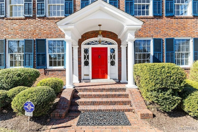 entrance to property featuring brick siding