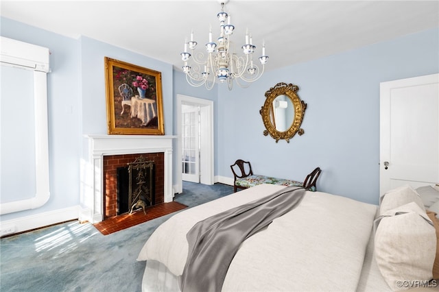 carpeted bedroom featuring a chandelier, a wall unit AC, baseboards, and a brick fireplace