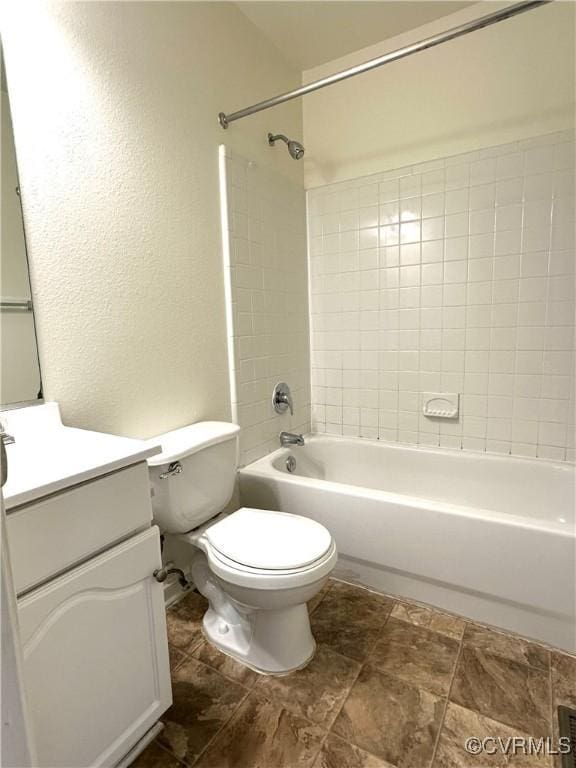 bathroom featuring tub / shower combination, a textured wall, vanity, and toilet