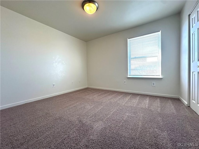 carpeted empty room featuring baseboards