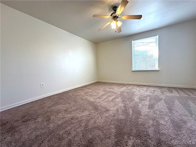 carpeted empty room with ceiling fan and baseboards