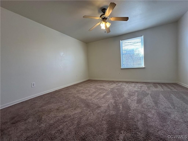 carpeted spare room featuring a ceiling fan and baseboards