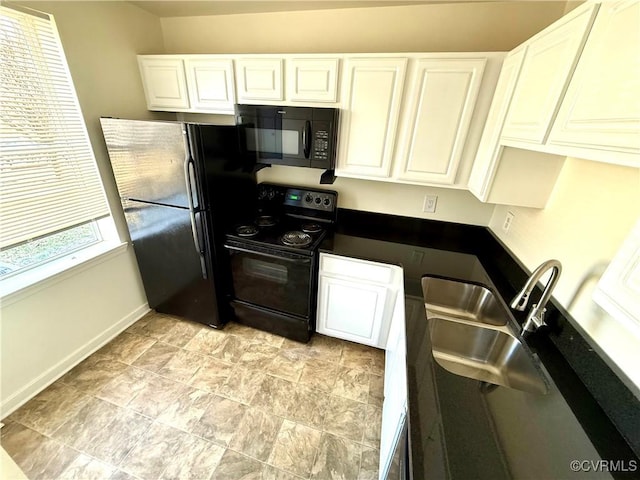 kitchen featuring black appliances, a sink, dark countertops, white cabinets, and baseboards