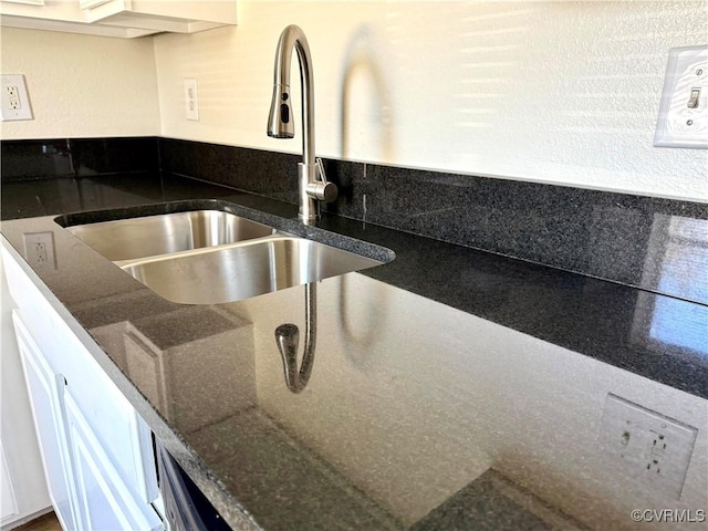 interior details featuring dark stone countertops and a sink