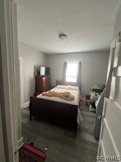 bedroom with dark wood-type flooring