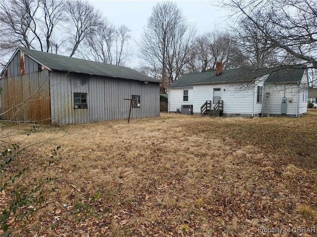 back of property featuring crawl space, a chimney, and cooling unit