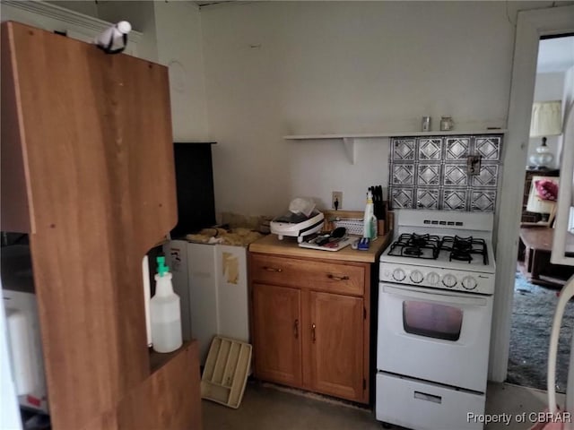 kitchen with brown cabinetry, light countertops, and gas range gas stove