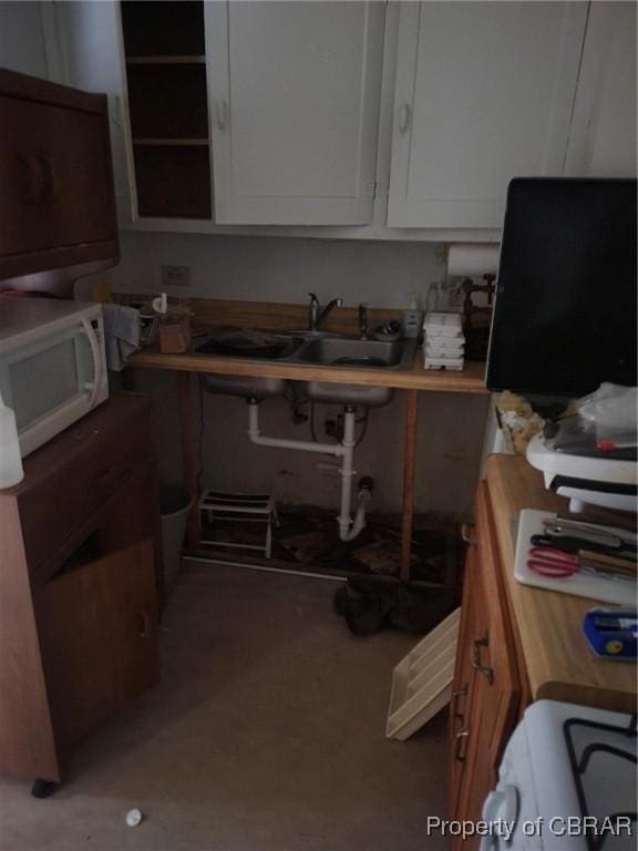 kitchen with white cabinets, a sink, and white microwave