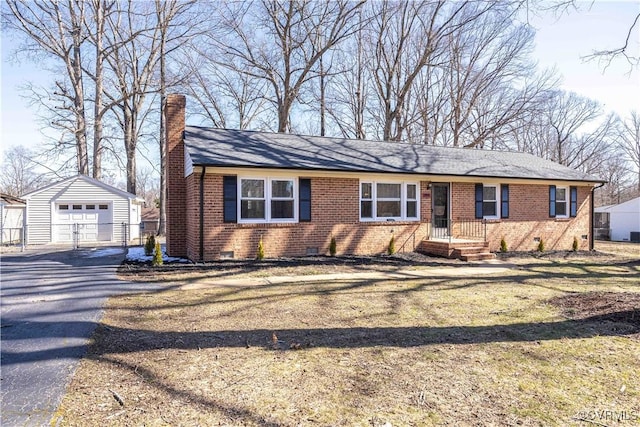 view of front of house featuring driveway, a chimney, an outbuilding, crawl space, and brick siding