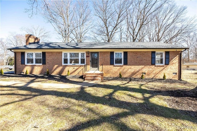 ranch-style home featuring crawl space, a front yard, a chimney, and brick siding