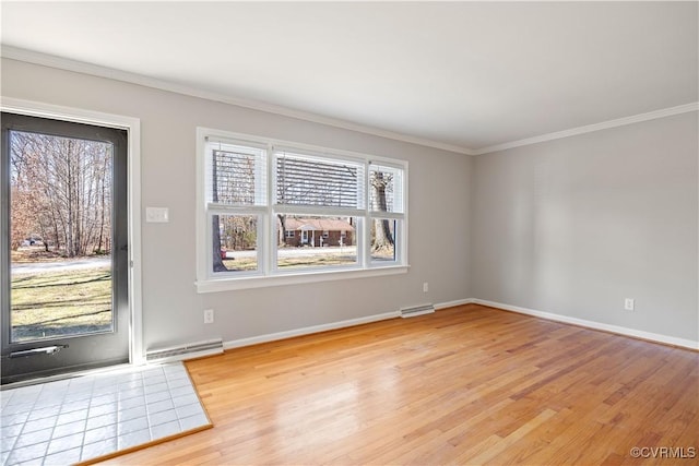 unfurnished room featuring baseboards, ornamental molding, visible vents, and light wood-style floors