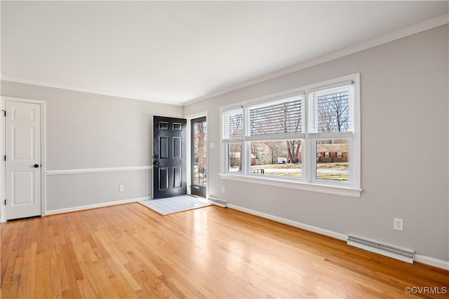 foyer featuring light wood-style floors, baseboards, visible vents, and crown molding