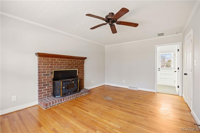 unfurnished living room featuring light wood-style floors, visible vents, crown molding, and baseboards