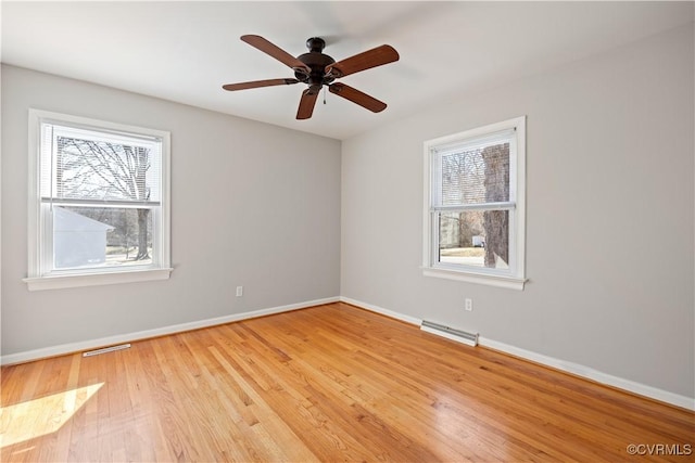 empty room with light wood-type flooring, baseboards, visible vents, and a ceiling fan