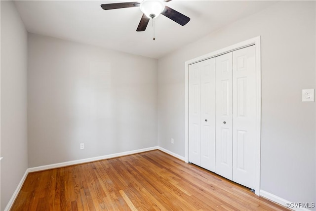 unfurnished bedroom featuring light wood-type flooring, a closet, and baseboards