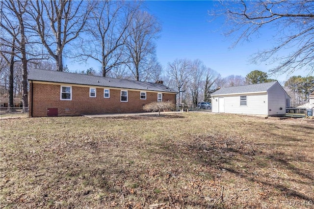 back of house featuring crawl space, a yard, fence, and brick siding