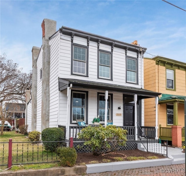 italianate house featuring a chimney, fence, and a porch