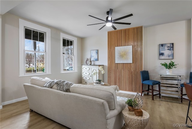 living room featuring ceiling fan, wood finished floors, and baseboards