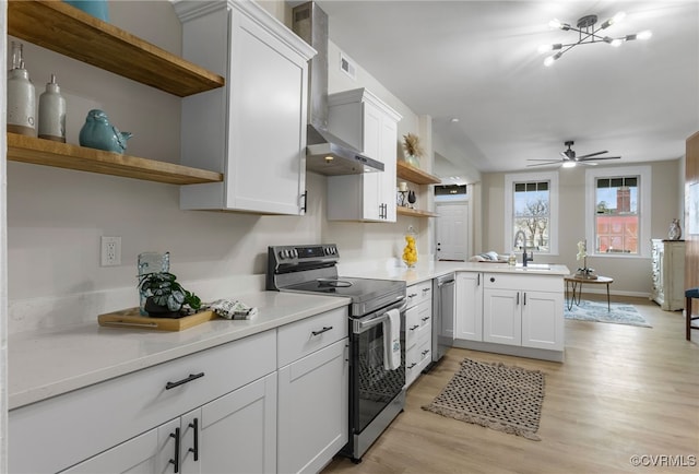 kitchen featuring a ceiling fan, appliances with stainless steel finishes, a peninsula, light countertops, and open shelves