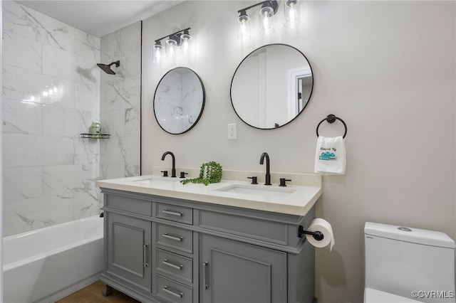 full bathroom with toilet, double vanity, a sink, and bathing tub / shower combination