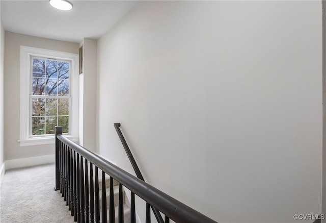 corridor with carpet flooring, an upstairs landing, and baseboards