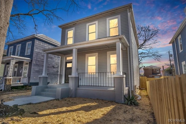 view of front of house featuring covered porch and fence