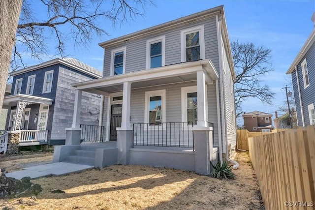 traditional style home with a porch and fence