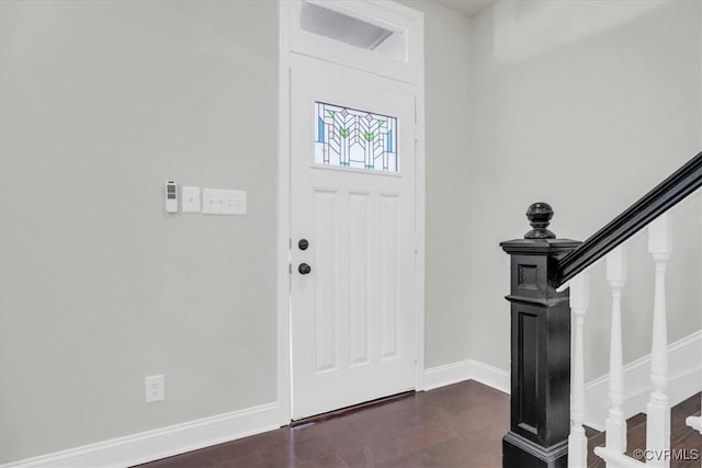 entrance foyer featuring stairway and baseboards