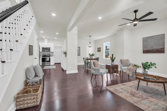 living area featuring ceiling fan, recessed lighting, dark wood-type flooring, baseboards, and stairs